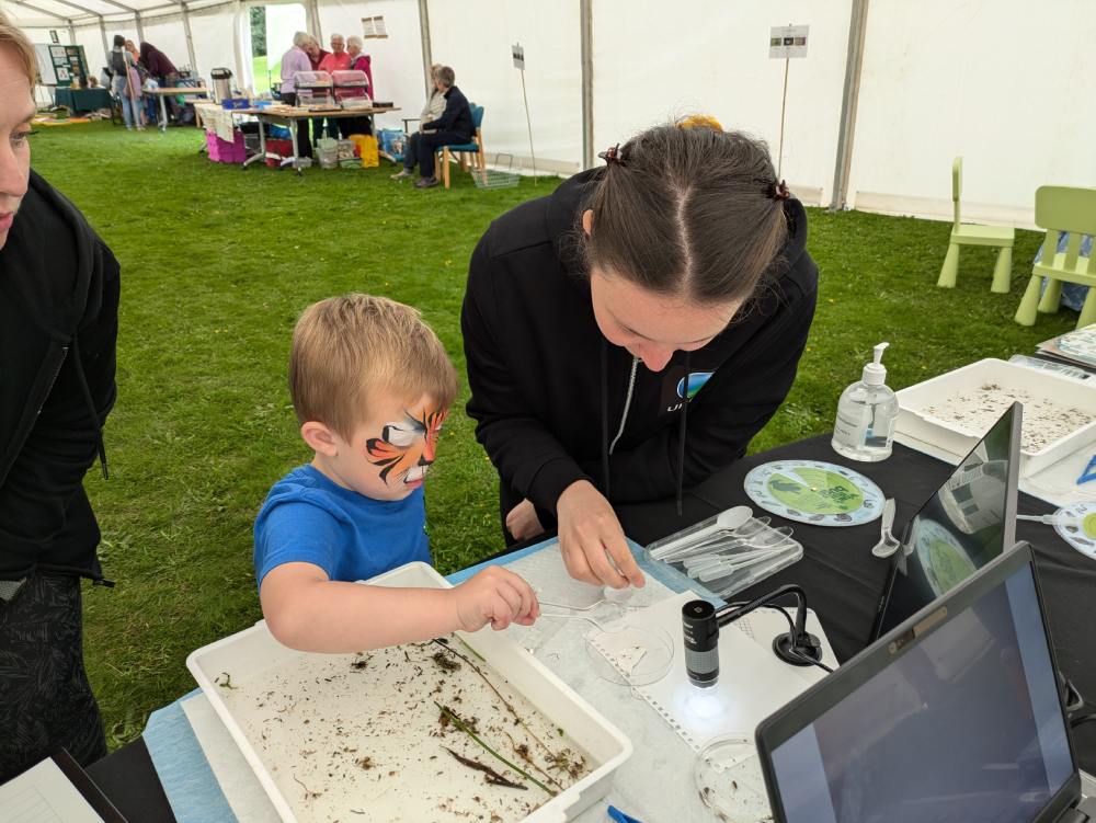 Erica Zaja showing local kids how to use the microscope.
